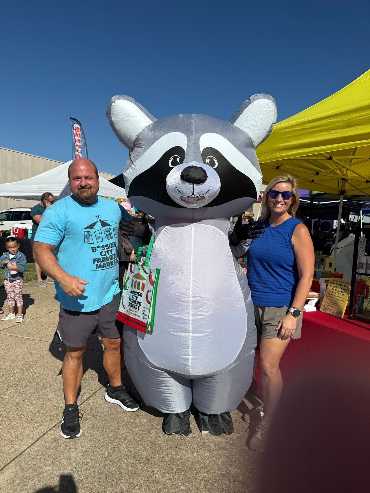 Beth Graham at the Bossier City Farmers Market with the market's inflatable raccoon mascot